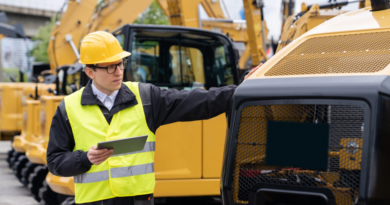 inspector with tablet looking at construction machine